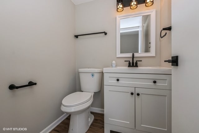 bathroom with hardwood / wood-style flooring, vanity, and toilet