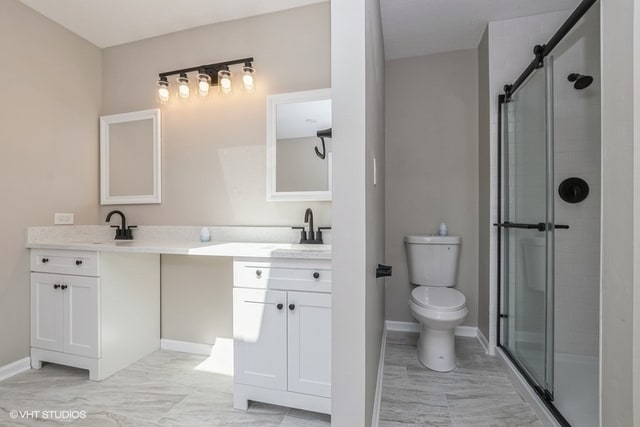 bathroom with vanity, a shower with shower door, and toilet