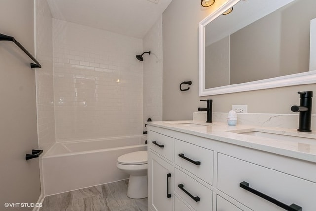 full bathroom featuring toilet, vanity, and tiled shower / bath