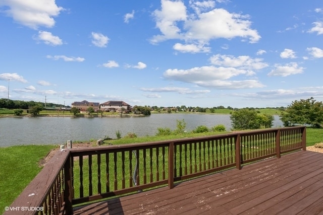 wooden deck with a yard and a water view