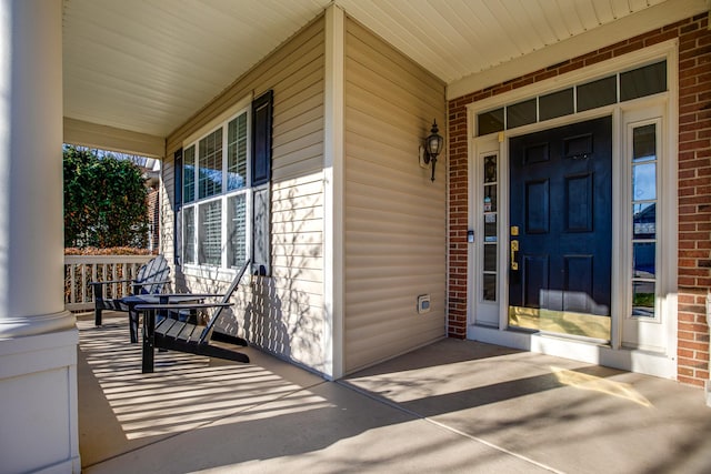 view of exterior entry featuring covered porch