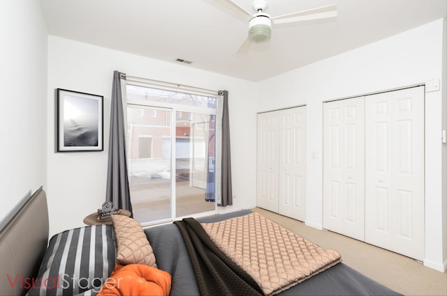 bedroom featuring carpet flooring, two closets, and ceiling fan