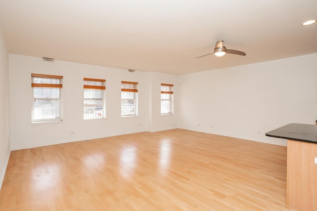 unfurnished living room featuring light hardwood / wood-style flooring and ceiling fan