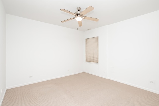 spare room with ceiling fan and light colored carpet