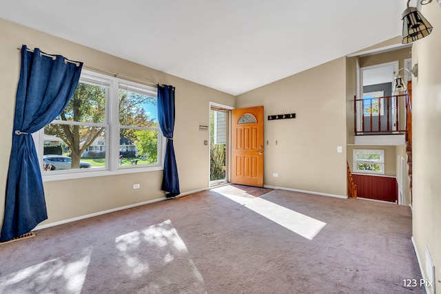 carpeted foyer featuring lofted ceiling