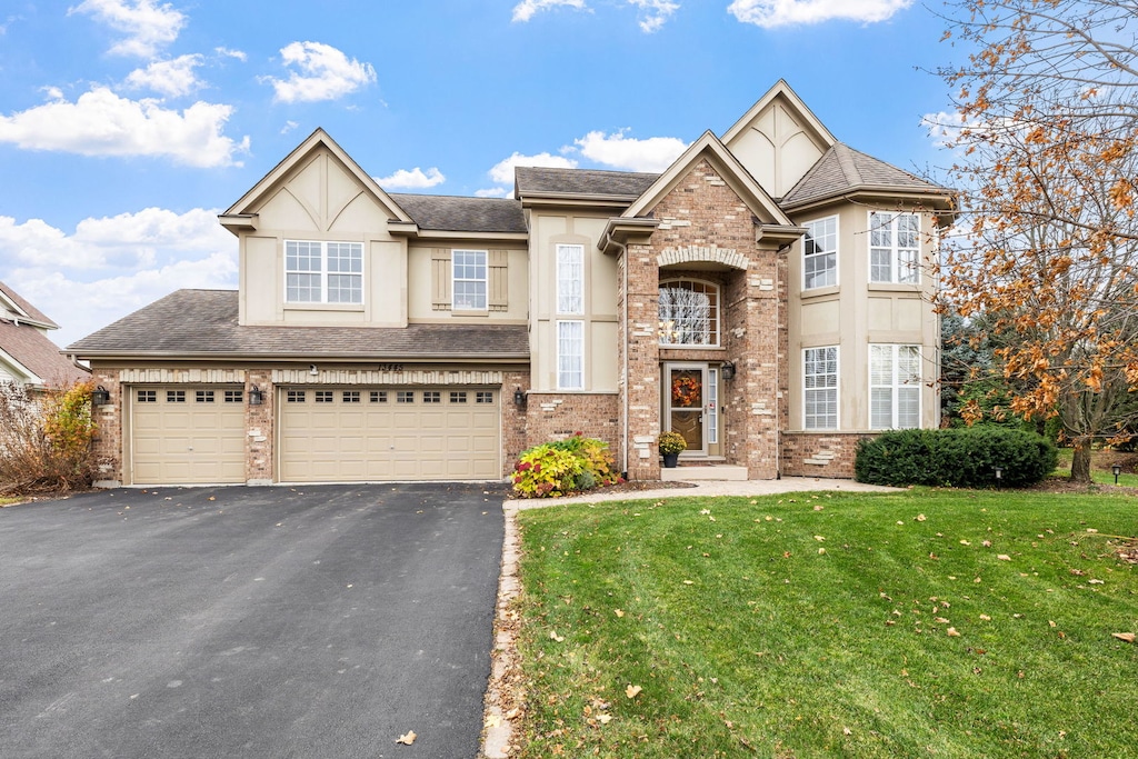 view of front of property with a front yard and a garage