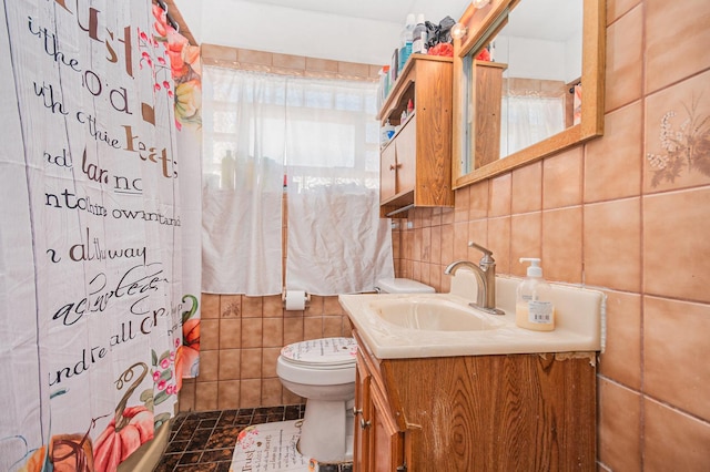 bathroom with tile walls, toilet, vanity, and a shower with curtain