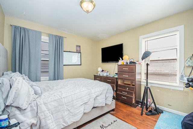 bedroom with hardwood / wood-style flooring and multiple windows