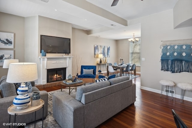 living room with ceiling fan with notable chandelier and dark hardwood / wood-style floors