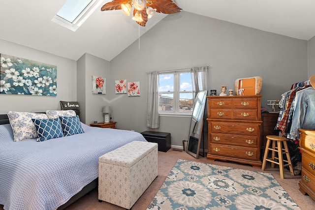 carpeted bedroom with ceiling fan, high vaulted ceiling, and a skylight