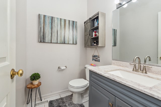 bathroom with toilet, vanity, and tile patterned floors