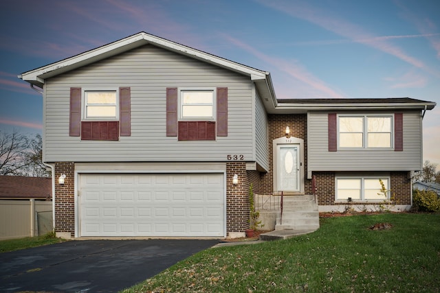 view of front of house with a garage and a lawn