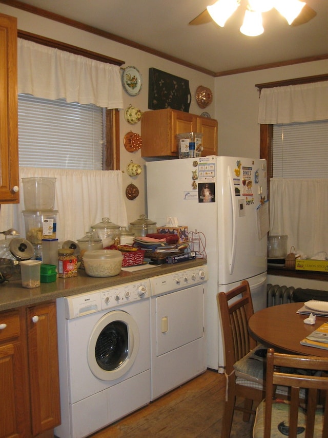 kitchen featuring ornamental molding, separate washer and dryer, ceiling fan, and dark wood-type flooring