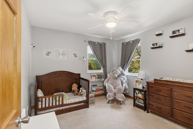 carpeted bedroom with multiple windows and ceiling fan