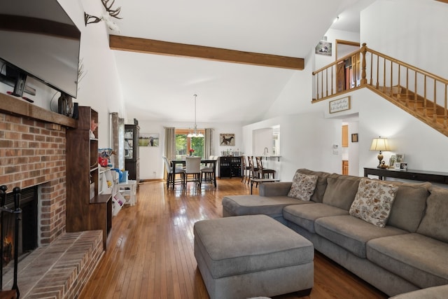 living room with a fireplace, hardwood / wood-style floors, beamed ceiling, and high vaulted ceiling