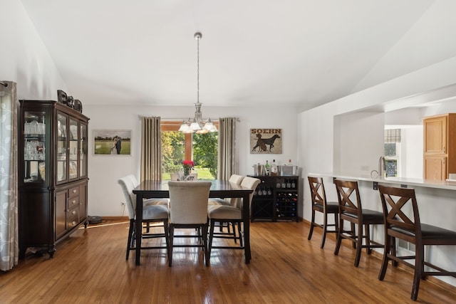 dining area featuring dark hardwood / wood-style flooring, a chandelier, and lofted ceiling