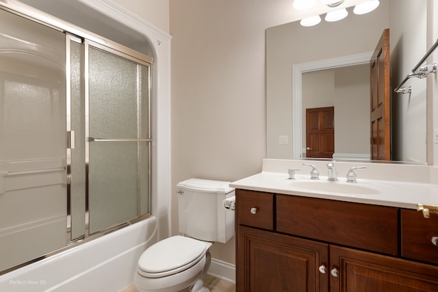 full bathroom featuring shower / bath combination with glass door, vanity, and toilet