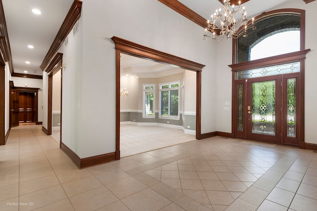 tiled foyer with a towering ceiling, an inviting chandelier, and ornamental molding