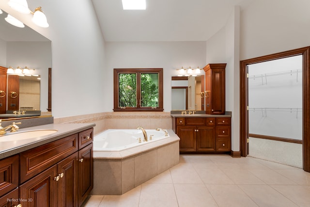 bathroom with vanity, tiled bath, and tile patterned floors