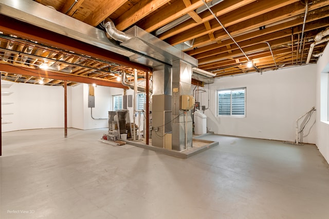 basement featuring electric panel and heating unit