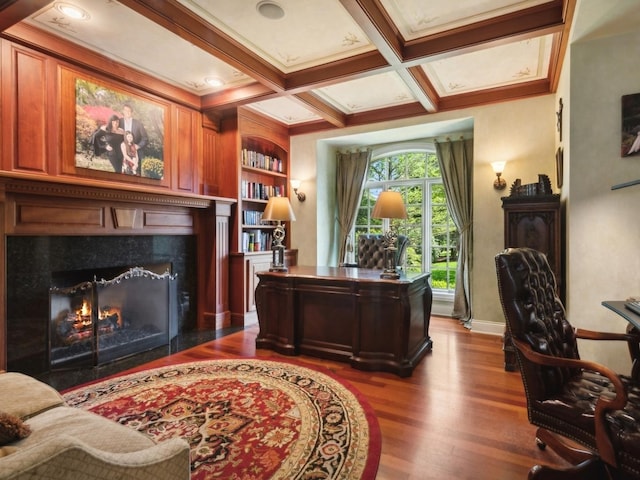 office featuring built in shelves, dark wood-style flooring, coffered ceiling, a high end fireplace, and beamed ceiling