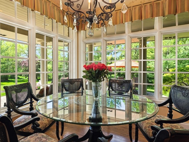 sunroom / solarium featuring a notable chandelier