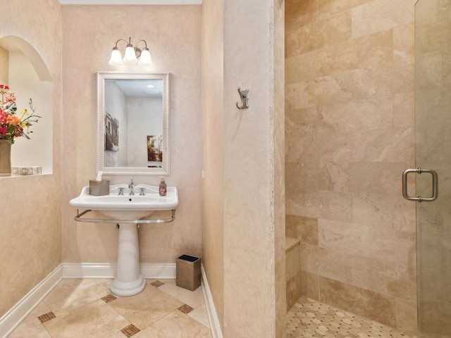 full bath featuring a stall shower, tile patterned flooring, and baseboards