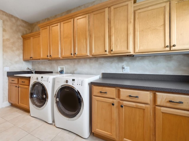 laundry area featuring cabinet space, washing machine and dryer, a sink, and light tile patterned flooring