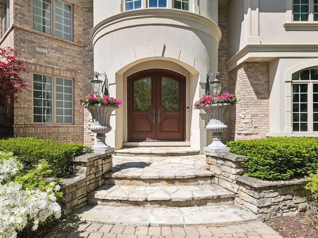 property entrance featuring brick siding and stucco siding