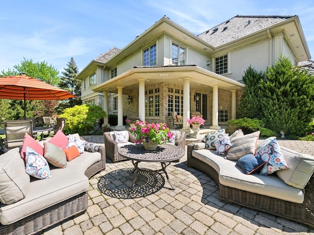 rear view of property with a patio area, outdoor lounge area, and stucco siding