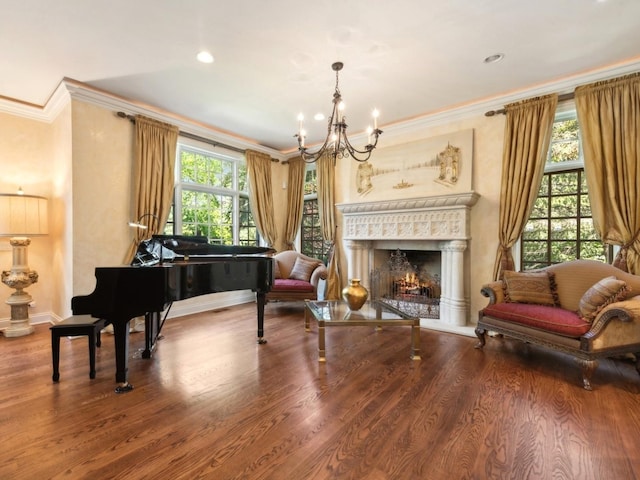 living area featuring a healthy amount of sunlight, a warm lit fireplace, crown molding, and wood finished floors