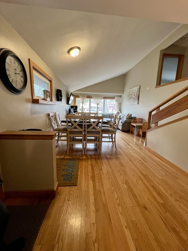 dining space featuring light hardwood / wood-style flooring and vaulted ceiling