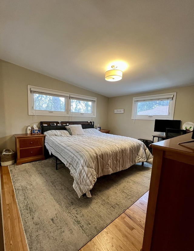 bedroom with wood-type flooring and lofted ceiling