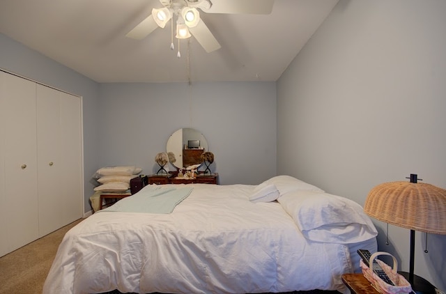 bedroom featuring ceiling fan, light colored carpet, lofted ceiling, and a closet