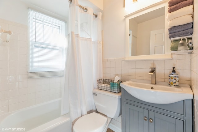 full bathroom with vanity, decorative backsplash, toilet, tile walls, and shower / tub combo