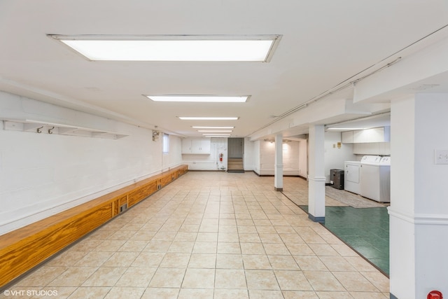 basement featuring washer and clothes dryer and light tile patterned floors