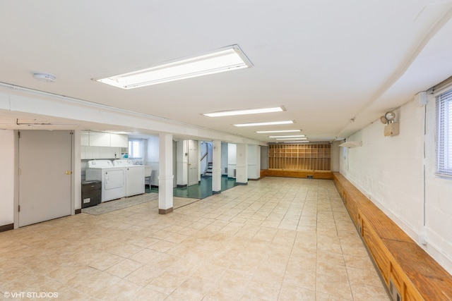 basement featuring independent washer and dryer and light tile patterned floors