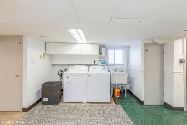 washroom with cabinets, washing machine and dryer, and sink