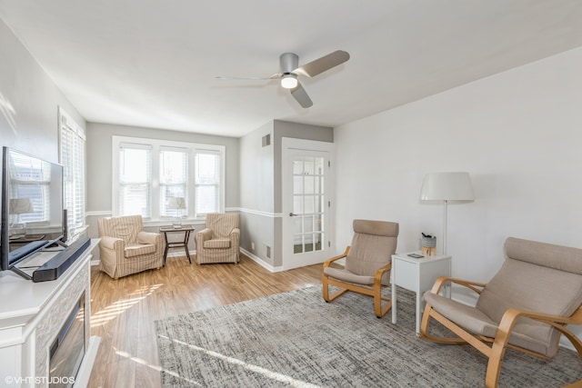 living area featuring light wood-type flooring and ceiling fan