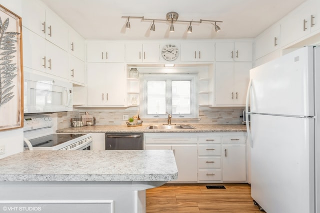 kitchen featuring sink, light hardwood / wood-style flooring, backsplash, white appliances, and white cabinets