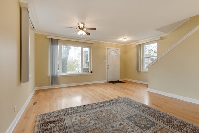 foyer entrance featuring ceiling fan, crown molding, and light hardwood / wood-style flooring