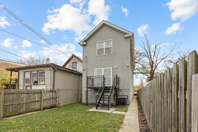 rear view of property with a yard and central AC