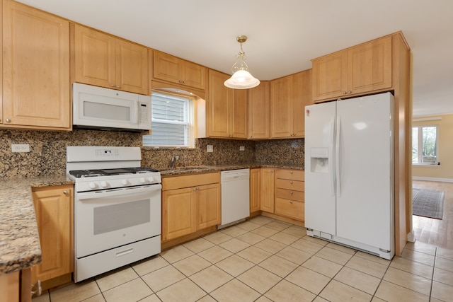 kitchen featuring white appliances, sink, pendant lighting, light tile patterned floors, and stone countertops