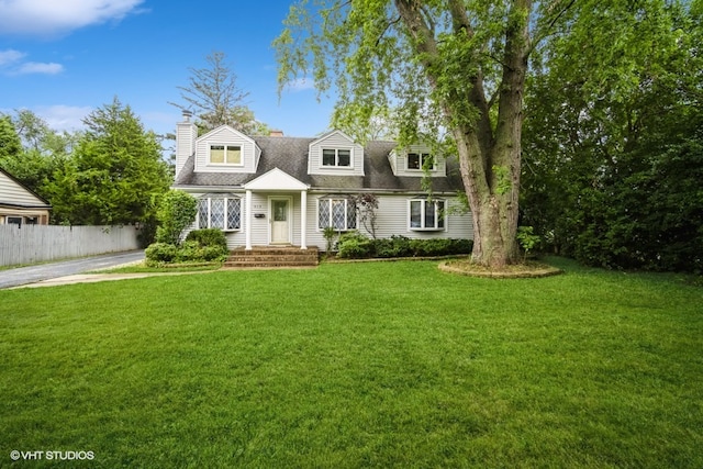 cape cod home featuring a front yard