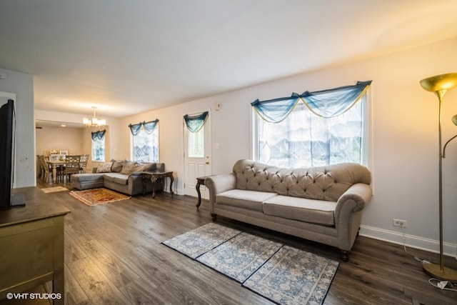 living room featuring dark hardwood / wood-style floors and an inviting chandelier