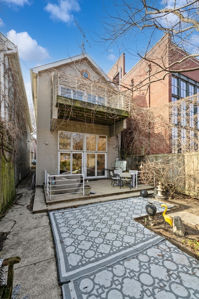 rear view of house with a patio area and a balcony