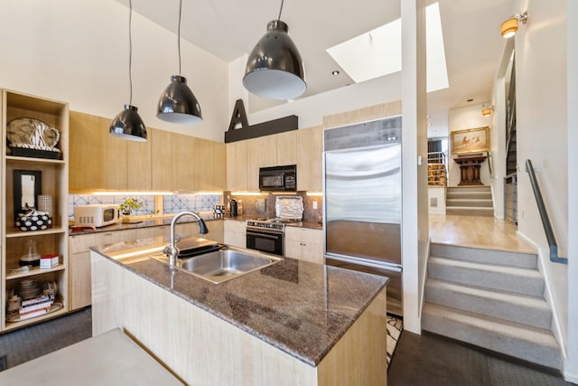 kitchen with decorative backsplash, appliances with stainless steel finishes, dark hardwood / wood-style flooring, dark stone counters, and sink