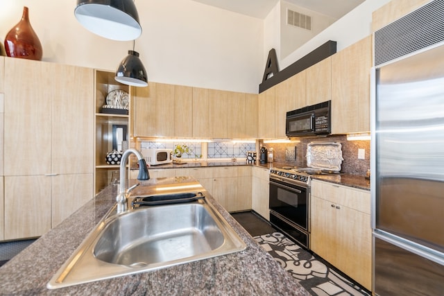 kitchen featuring backsplash, gas stove, sink, light brown cabinets, and stainless steel built in fridge