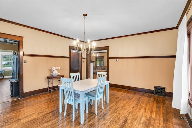 dining room with dark hardwood / wood-style flooring, an inviting chandelier, and ornamental molding