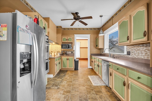 kitchen with decorative backsplash, appliances with stainless steel finishes, ceiling fan, sink, and decorative light fixtures